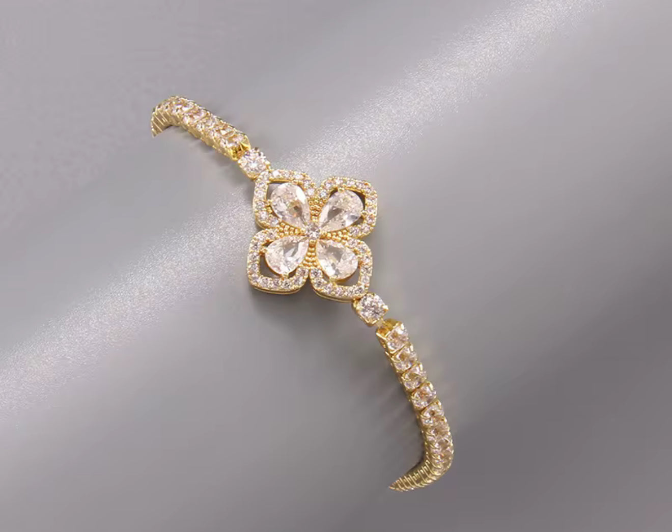 Elegant gold floral bracelet with sparkling CZ petals and a radiant centerpiece, perfect for luxury-inspired fashion or bridal looks.
